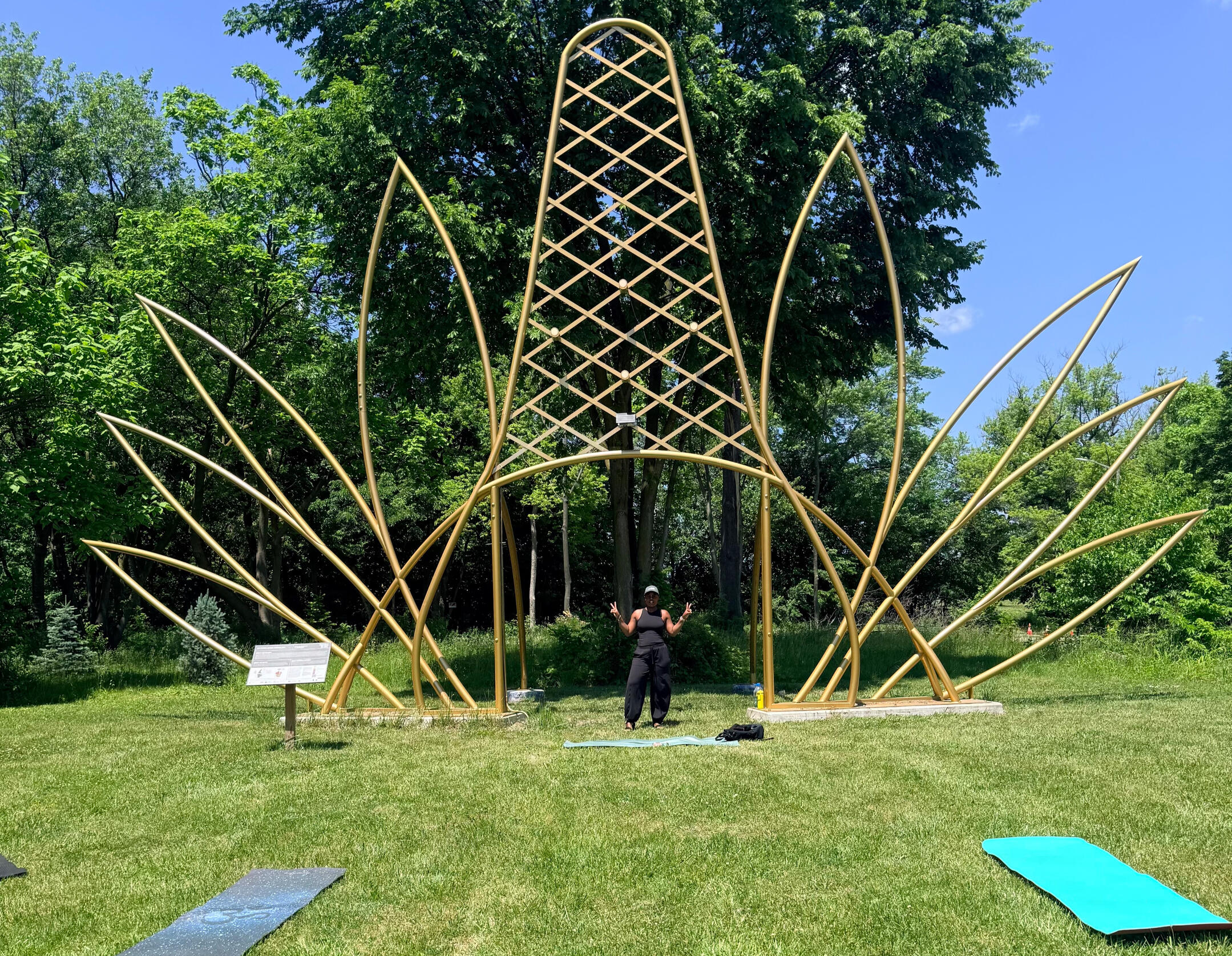 woman standing under gold crown sculpture
